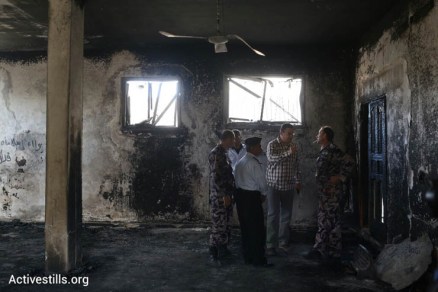Local officials and Palestinian police stand in a mosque damaged in a suspected arson hate crime in the West Bank village of Al Mughayir, November 12, 2014. (Photo by Oren Ziv/Activestills.org)