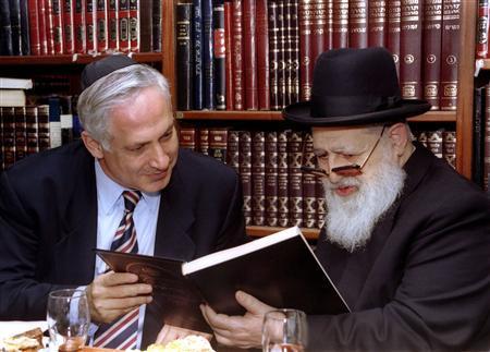 Then Israeli Prime Minister-elect Benjamin Netanyahu (L) and Rabbi Ovadia Yosef read the dedication of a Jewish religious book given to Netanyahu by Yosef during a meeting in this June 13, 1996 file photo.
