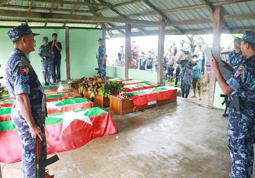 Myanmar Border Police on October 11 prepare the flag-draped coffins bearing nine bodies of border guards killed two days earlier.AFP